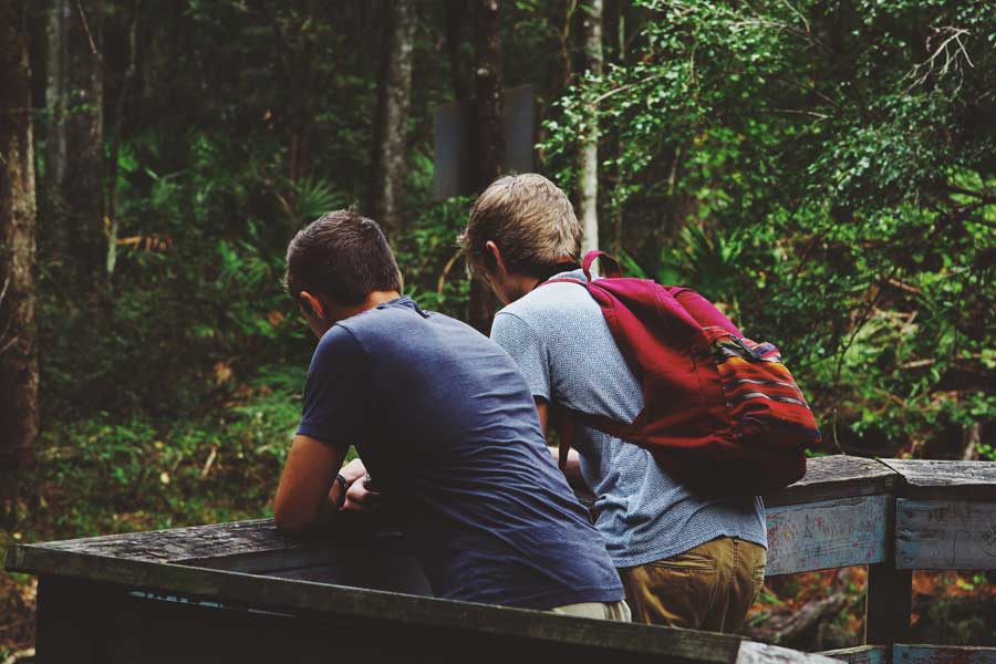 Two teenagers chatting with their back turned