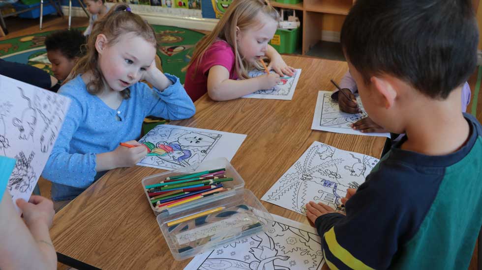 Young children coloring together on a table